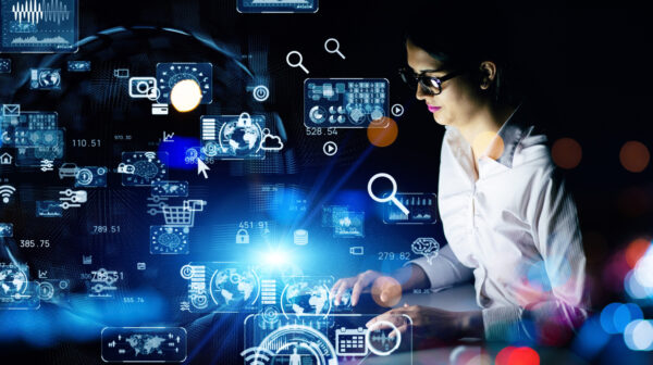 Young woman working in the night office. System engineering. Digital transformation.